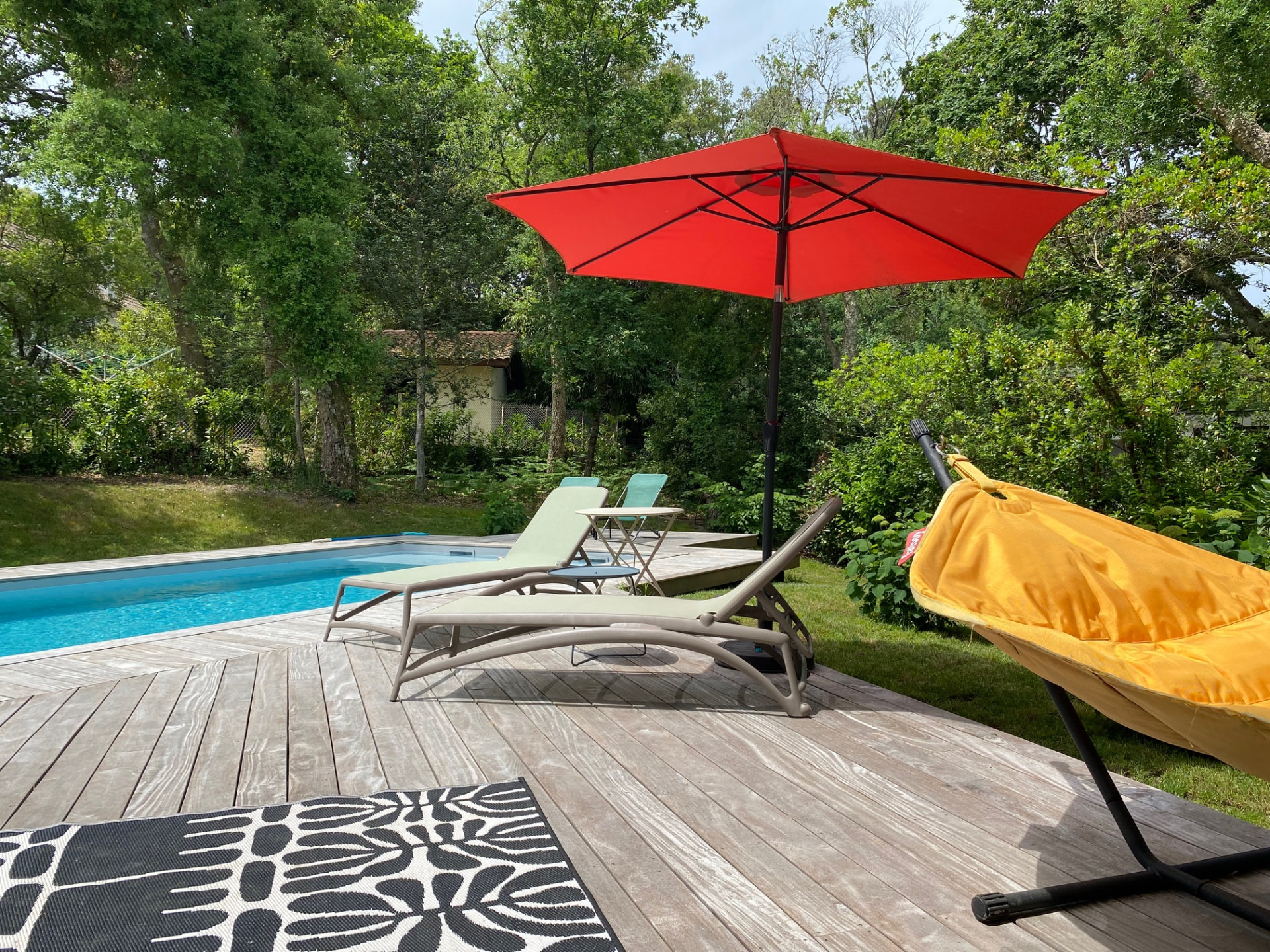La terrasse et les transats au bord de la piscine chauffée